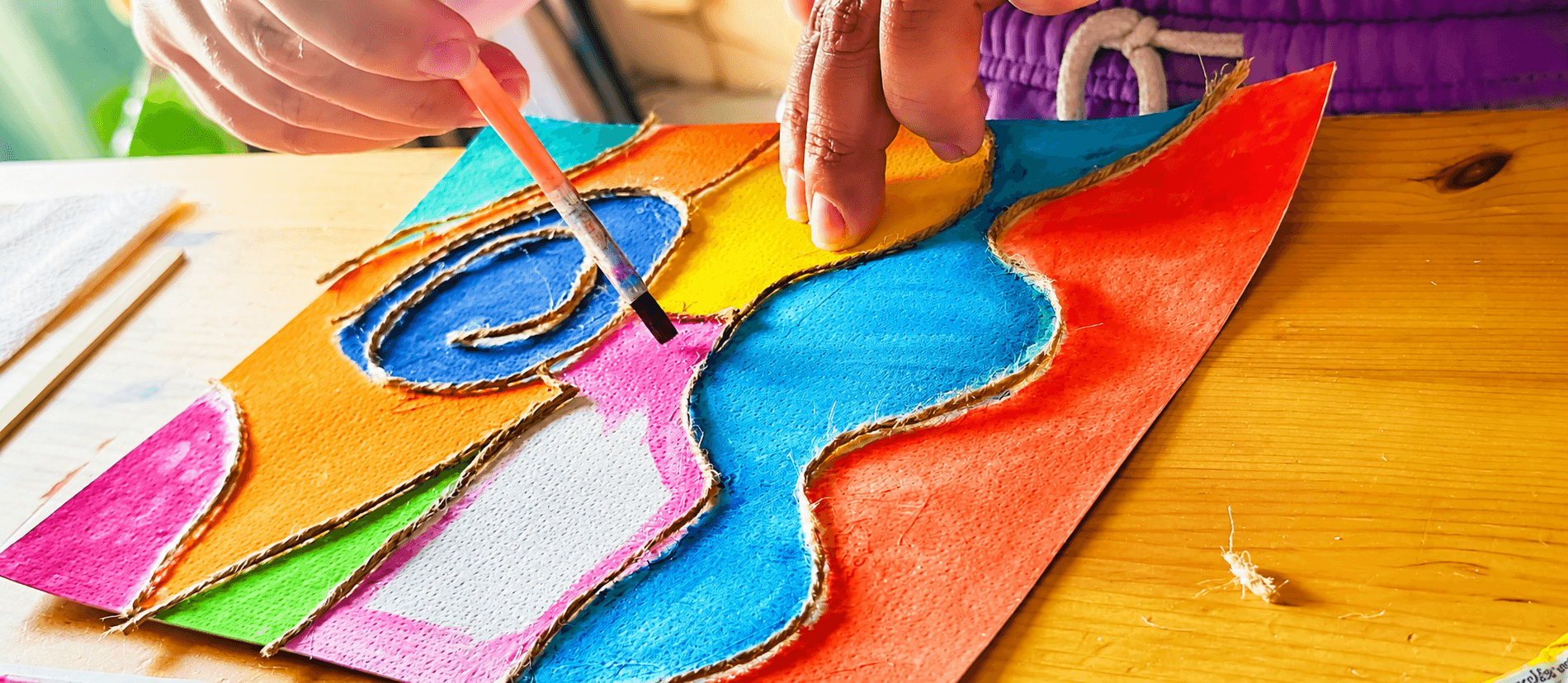 Criança concentrada a pintar um quadro no ateliê